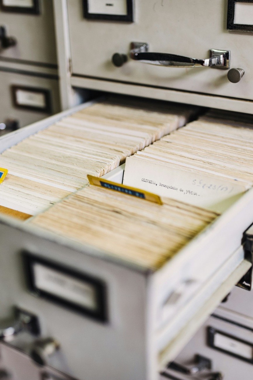 An open archive drawer, densely packed with indexed record cards